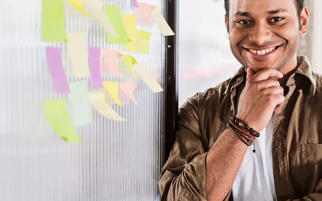 Joyful man beside a whiteboard